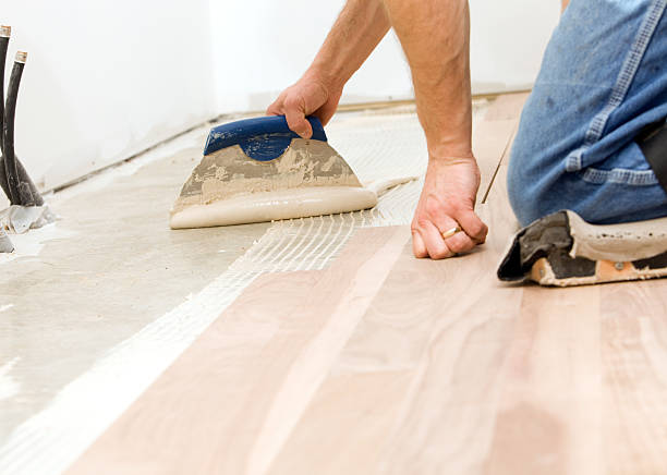 istock Worker Troweling Adhesive for a Hardwood Floor over Concrete 183767018
