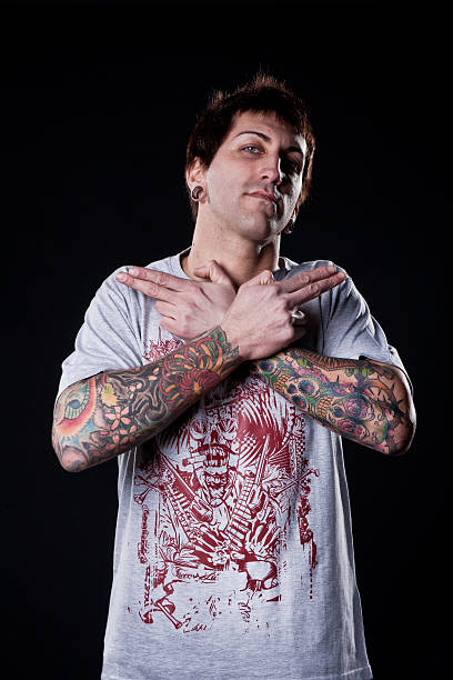istock Tattooed man crossing his arms with gun form. 183767206