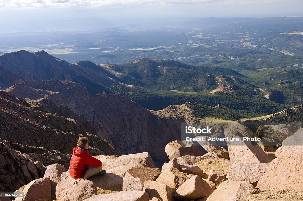 Vista Scenic View from Pikes Peak Summit Colorado "Vista Scenic View from Pikes Peak Summit Colorado.  Hiker enjoying scenic view on beautiful, sunny day.  Young athletic man kicking back on warm sunny rocks.  Legs outstretched in front.  Captured as a 14-bit Raw file. Edited in ProPhoto RGB color space." Colorado Springs Stock Photo