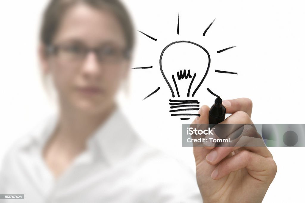 Idea Businesswoman drawing a bulb on a virtual whiteboard. Metaphor for Ideas and Inspiration. Light Bulb Stock Photo
