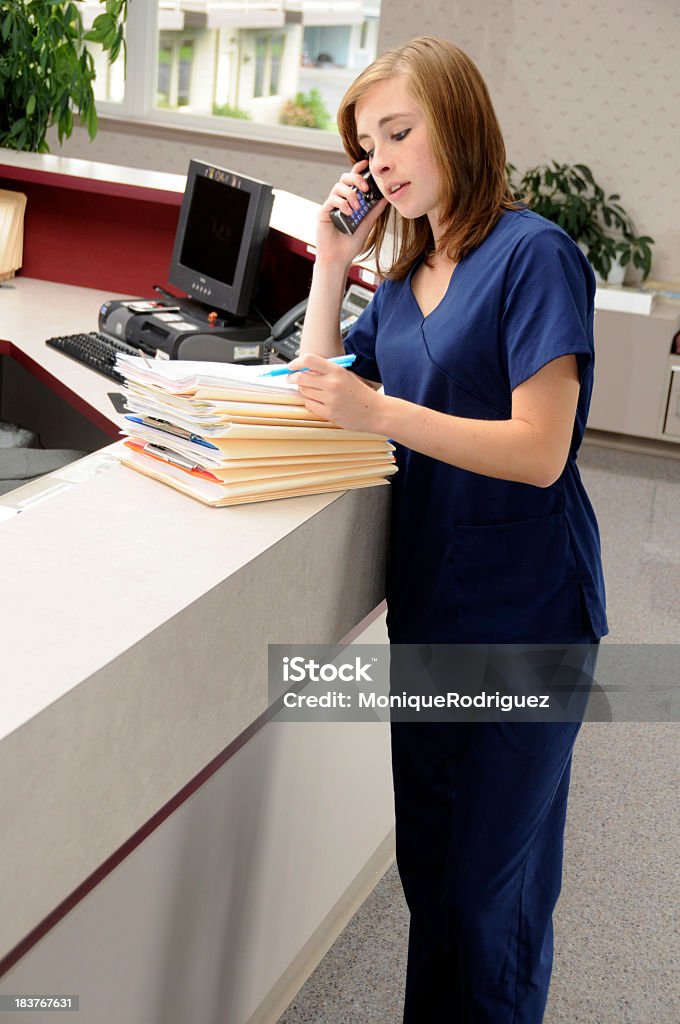 Медицинский сотрудник стойки регистрации с файлами и телефон - Стоковые фото Офис роялти-фри