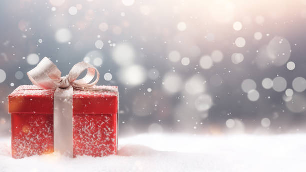Red Gift Box in Snow with Bokeh Background