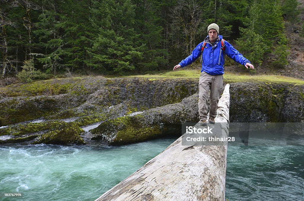 Hiker crossing log "A man crosses a log high above a river. Clackamas River, Oregon. See also these similar images:" 20-29 Years Stock Photo