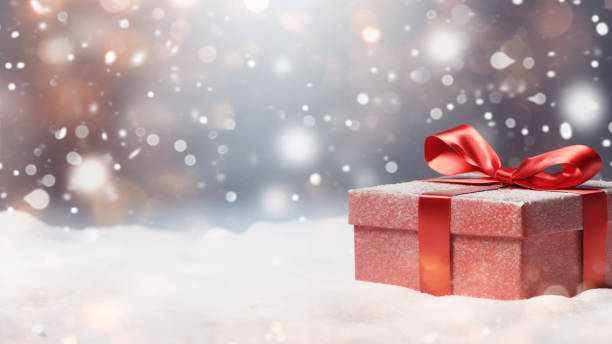 istock Red Gift Box in Snow with Bokeh Background 1837679973