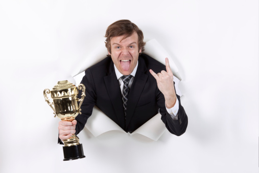 Businessman holding trophy emerging from a hole in paperhttp://www.twodozendesign.info/i/1.png