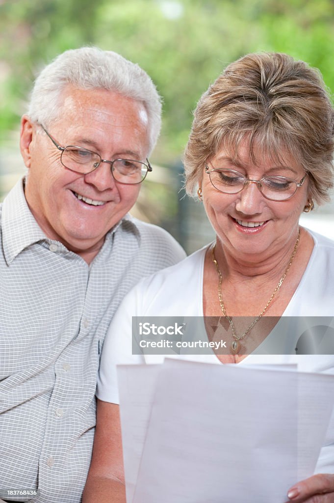 couple d'âge mûr parler et sourire à la recherche de documents - Photo de Adulte libre de droits