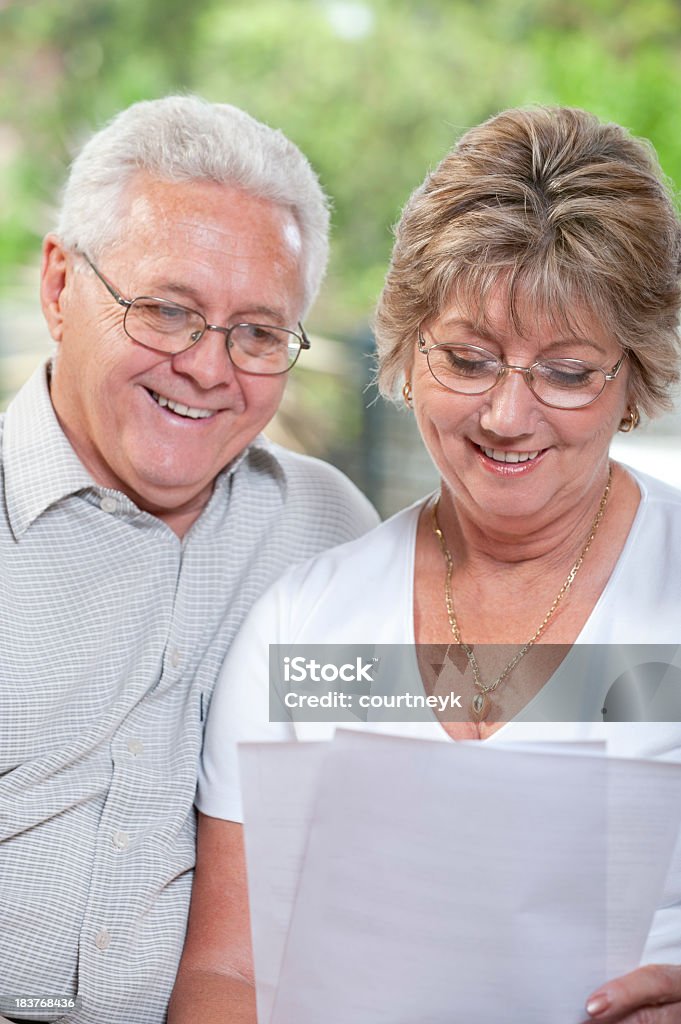 Casal falando e sorrindo olhando no documento - Foto de stock de Adulto royalty-free