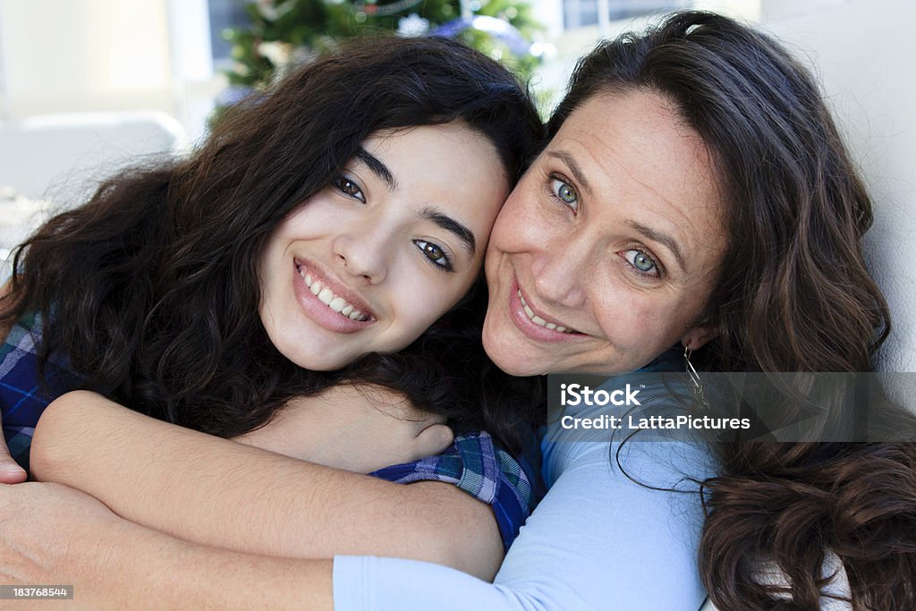 Mid adult mother and teenage daugther embracing Hispanic mature female and teenager hugging Mother Stock Photo