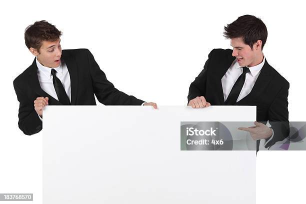 Dos Empresarios Con Un Cartel Foto de stock y más banco de imágenes de Indicar - Indicar, Sorpresa, Unión