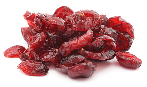 Pile of dried shriveled red cranberries on white background Dry cranberries pile on white background cranberry stock pictures, royalty-free photos & images