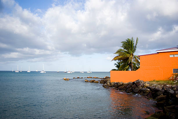 bright orange beach house and yachts sailing in background