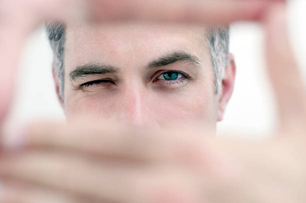 Man looking through hands in a rectangular shape stock photo