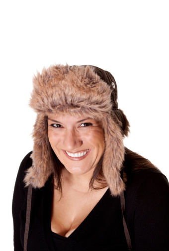 Profile of a smiling woman in a furry winter hat.
