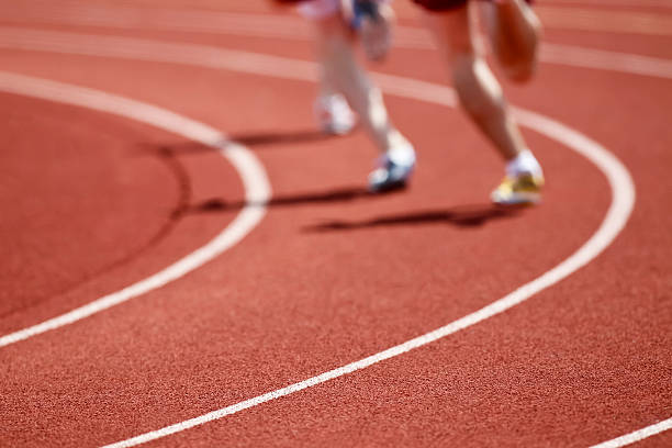 Two runners on a track in running shoes racing