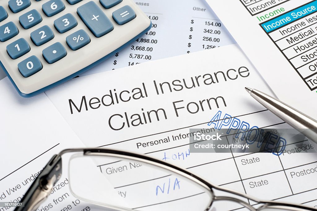 Approved Medical insurance claim Close up of approved Medical insurance claim form with pen glasses and calculator Benefits Stock Photo