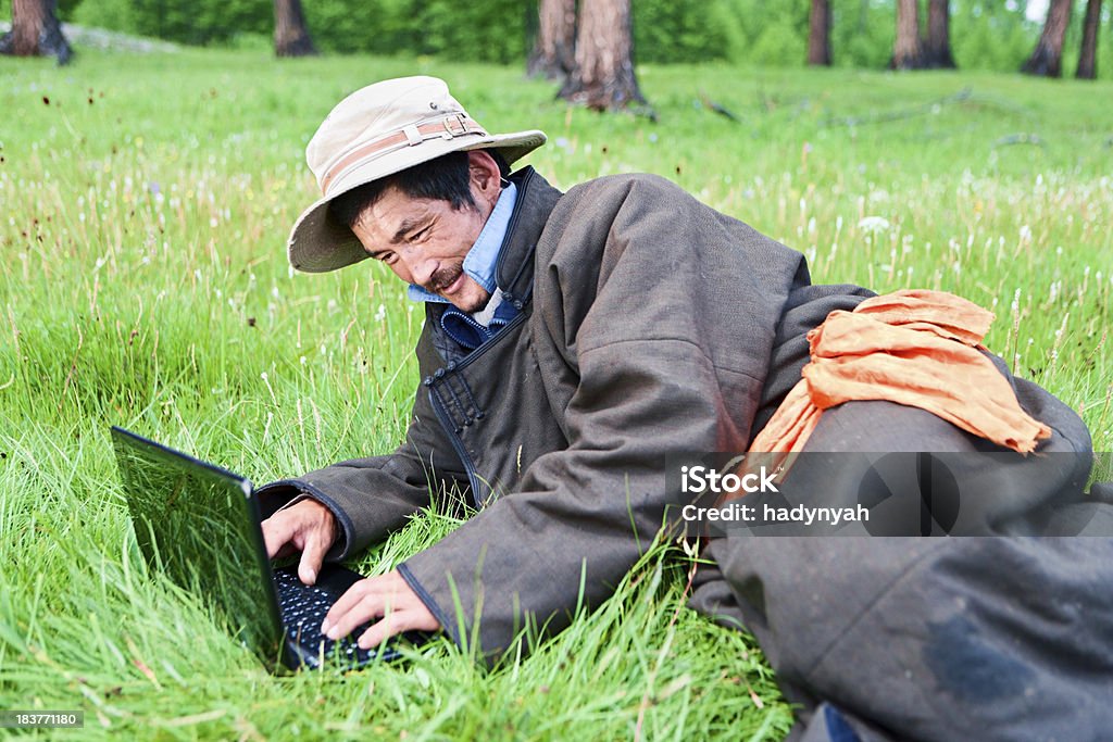 Mongolische Mann-Kleidung mit laptop - Lizenzfrei Asiatische Kultur Stock-Foto