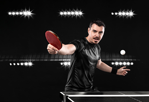 Table tennis player on the black background. Ping pong banner. Download a photo of a table tennis player for a tenis racket packaging design. Image for tennis ball box template.