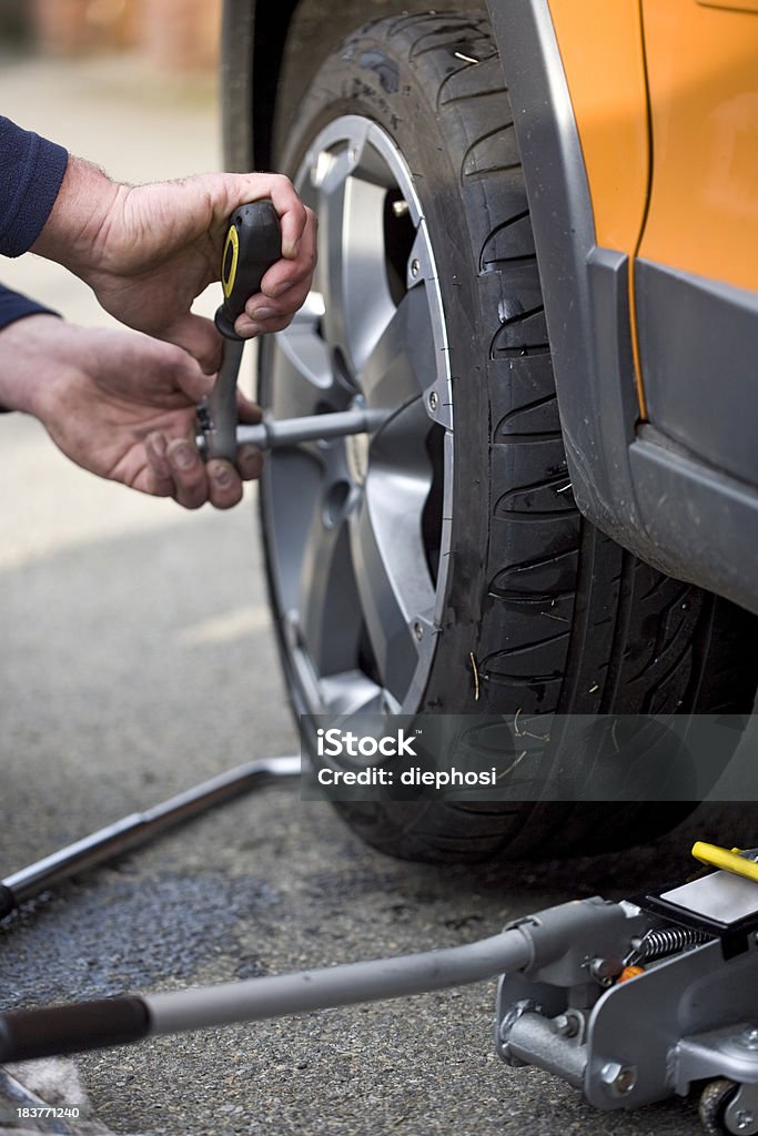 Changing a wheel a man attached to a wheel on the car Flat Tire Stock Photo