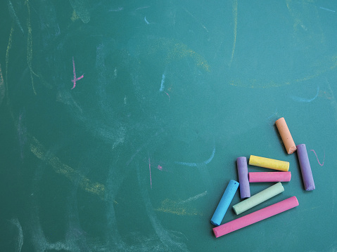Multicolor chalks on chalkboard for education background