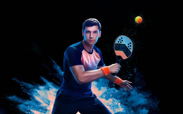istock Beach tennis player with racket. Man athlete playing isolated on black background. 1837717875