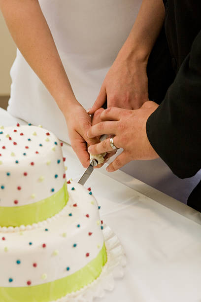 istock Bride and Groom's hands cutting wedding cake ring sprinkles greeen 183772069