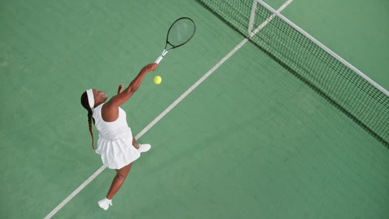 SLO MO LD Above a female tennis player failing to strike the ball