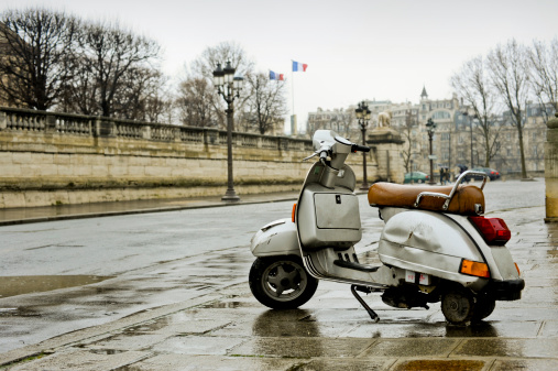 A beaten up scooter sits abandoned in the centre of Paris.