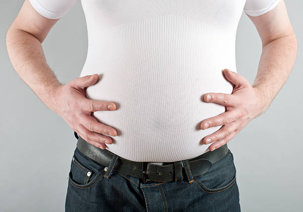 homem segurando pot belly - abdomen too small jeans overweight - fotografias e filmes do acervo