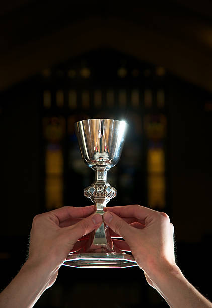Woman's hands putting a communion wafer into a man's hands