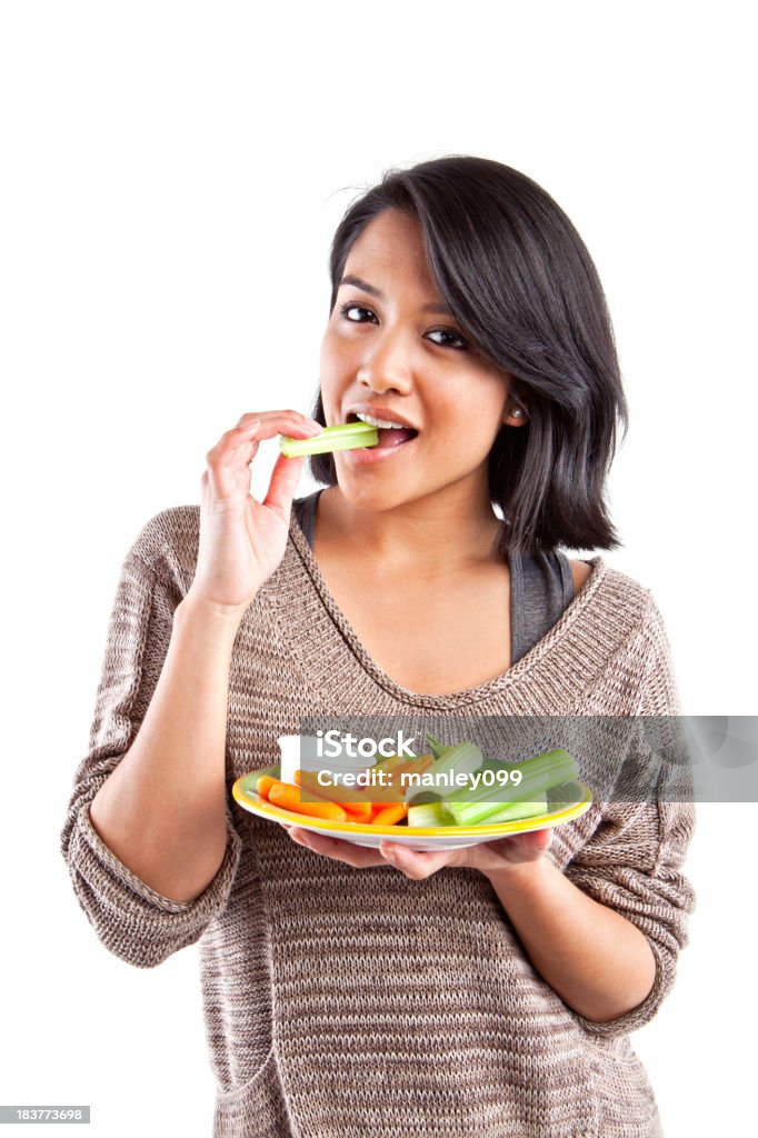 teenage girl eating vegetables Girl eating vegetables Adult Stock Photo