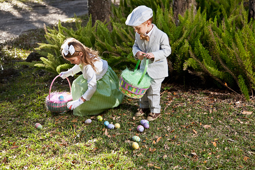 Girl and litte brother looking for easter eggs.  6 and 3 years.