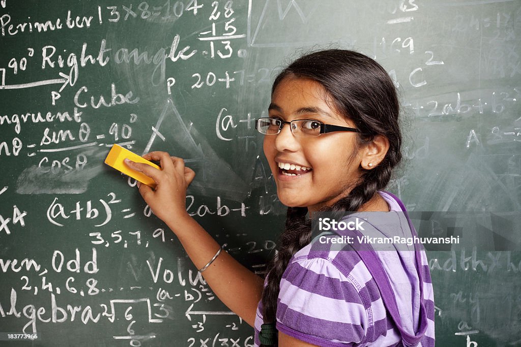 Alegre menina estudante indiana eliminar matemática problemas de Greenboard quadro-negro - Foto de stock de Símbolo Matemático royalty-free