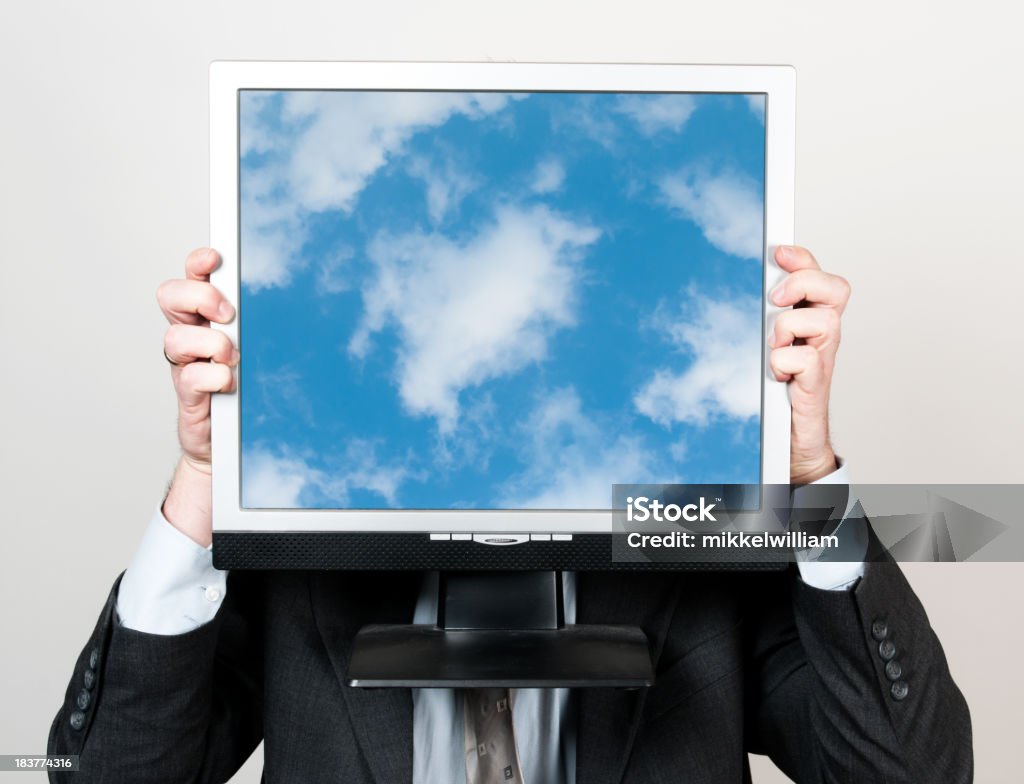 Business man and cloud computing Businessman holds a monitor in front of his face. The screen shows clouds and a blue sky. Concept: Cloud computing. Blue Stock Photo