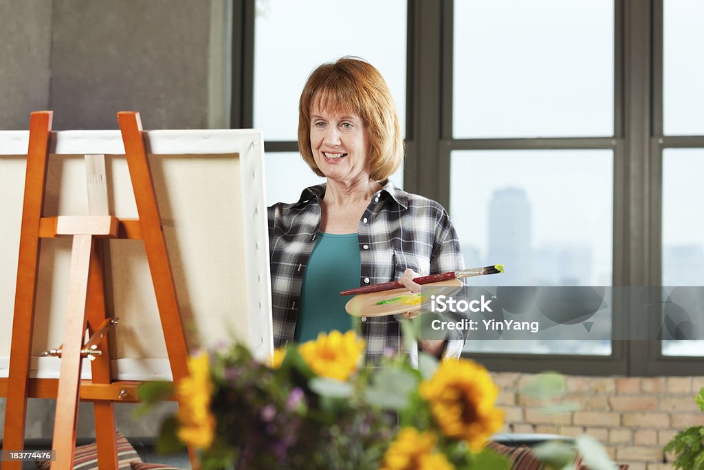 Media edad mujer jubilada Hobby pintura en el Loft condominio - Foto de stock de 50-59 años libre de derechos