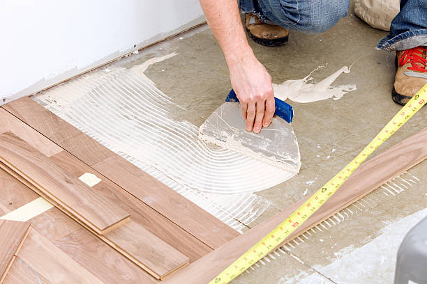 istock Worker Troweling Adhesive for a Hardwood over Concrete Floor 183774782