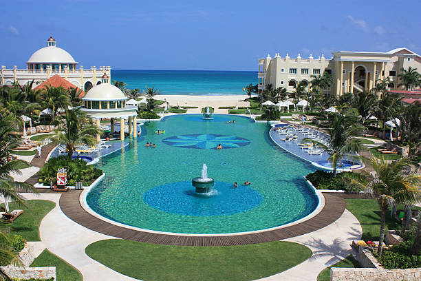 Resort infinity pool overlooks tropical beach, palm trees, and Caribbean Sea. Roatan, Honduras