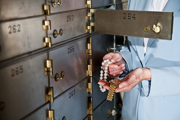 woman putting jewelry in safety deposit box - 銀行保管箱 個照片及圖片檔