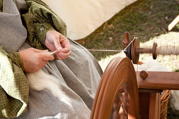 Woman at spinning wheel, spinning yarn.  This was taken inside a tent at a Civil War re-enactment.  There is some motion in her hands.