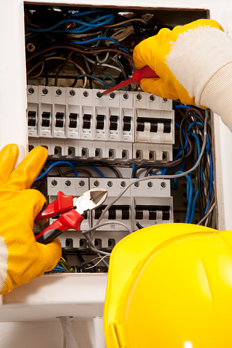 Electrician is repairing electrical failure on the fuse box