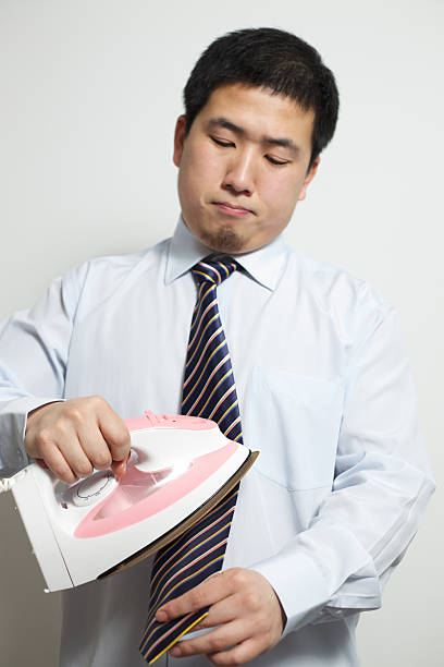 Businessman irons his tie