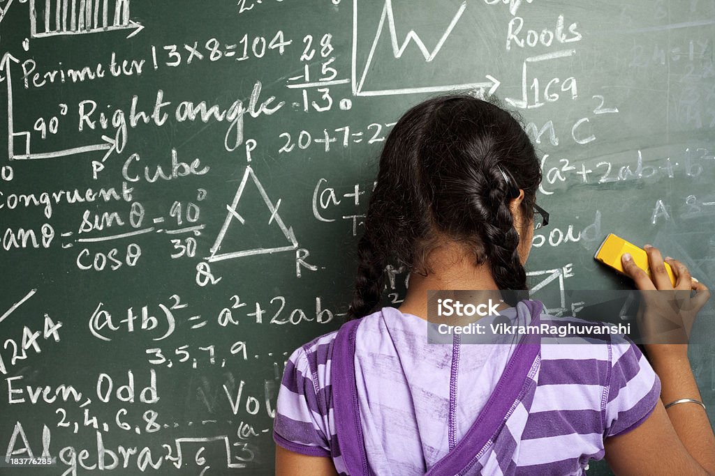 Indian Rapariga estudante Apagar matemática problemas de Greenboard Quadro Negro - Royalty-free Educação Foto de stock