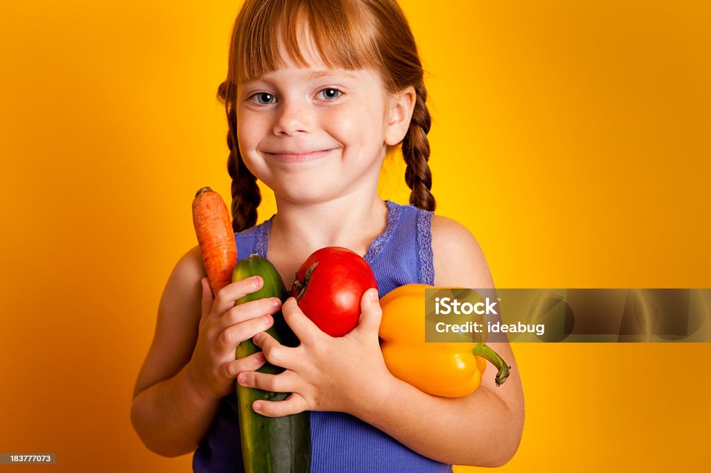 Bambina felice che tiene carota, Zucchini, pomodori, peperoni gialli - Foto stock royalty-free di 4-5 anni