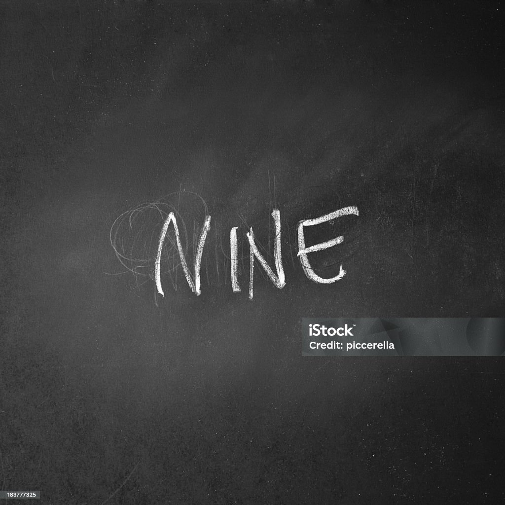 Glyph Of The Number NINE Written On A Blackboard Glyph of the number NINE written on a blackboard with chalk. Black And White Stock Photo