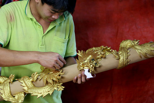 An Asian man is working in Dragon Sculpture Joss stick factory