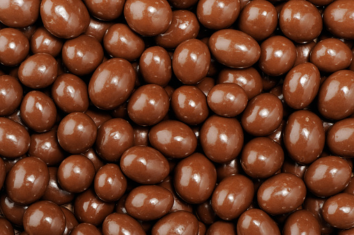 Stack of peanuts dipped in milk chocolate. 