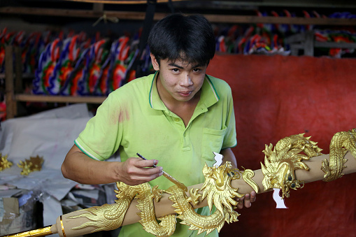 An Asian man is working in Dragon Sculpture Joss stick factory