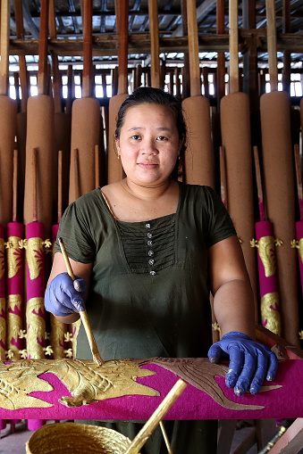 A Myanmar ethnicity woman is working at Dragon Sculpture Joss stick factory daily production