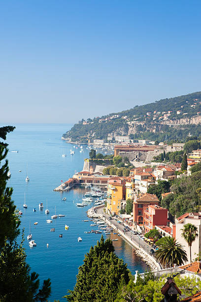 Villefranche-sur-Mer filled with boats off the shoreline The French Riviera resort of Villefranche sur Mer, located just outside Nice. The bay of Villefranche is one of the deepest natural harbours of any port in the Mediterranean Sea and provides safe anchorage for large ships, including cruise ships. The port is a popular destination for tourists with shopping, restaurants, and churches. nice france restaurant stock pictures, royalty-free photos & images