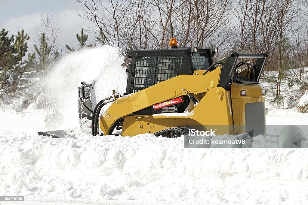 Sidewalk Snow Blower Multi purpose mini loader with a snow blower attachment removes snow from a city sidewalk. Activity Stock Photo
