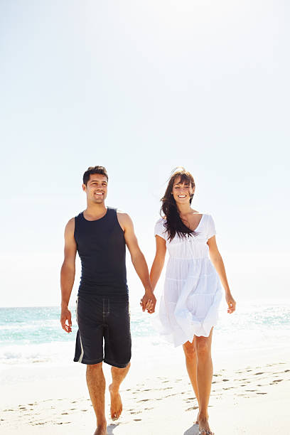 istock Cute couple walking along the beach 183779164
